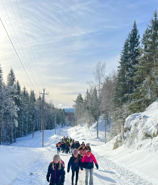 en gruppe mennesker som går på en snødekt sti