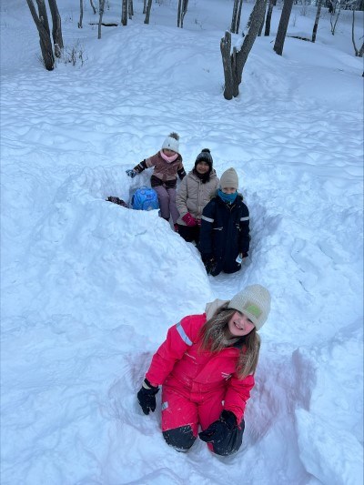 En gruppe mennesker som sitter i snøen