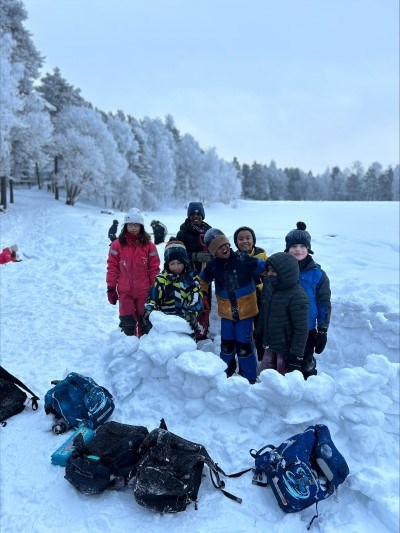 En gruppe mennesker som står i snøen