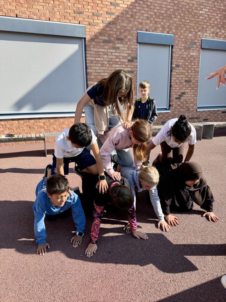en gruppe mennesker som kneler foran en murbygning