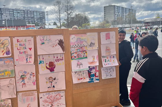 en gruppe mennesker som står ved siden av en vegg med plakater på