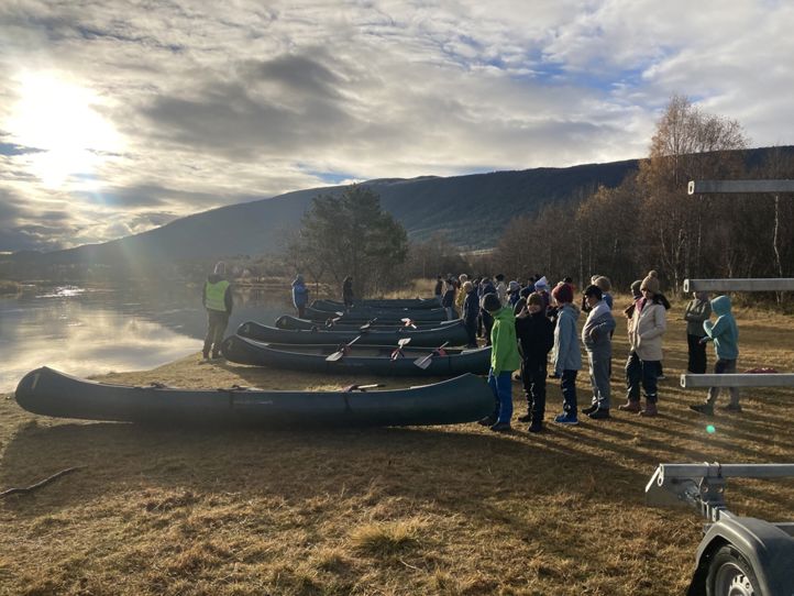 en gruppe mennesker som står rundt en gruppe båter på et grusfelt en gruppe mennesker som står rundt en gruppe båter på et grusfelt