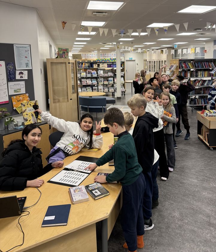 en gruppe mennesker som står rundt et bord med bøker på