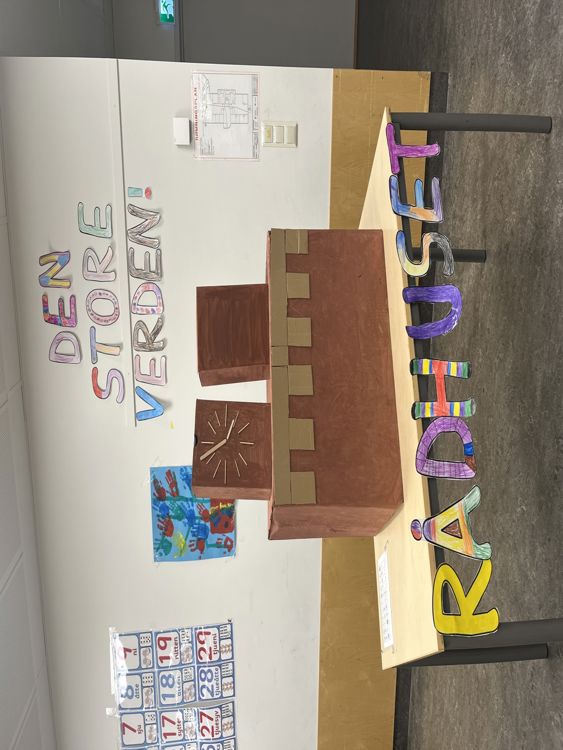 en trekasse med et skilt på foran en hvit vegg