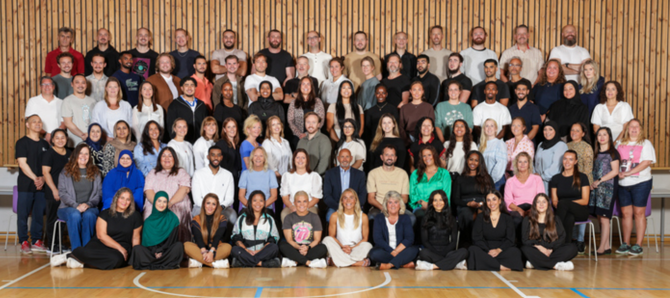 en gruppe mennesker som poserer for et bilde